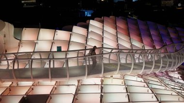 İspanya, Sevilla 'da Metropol Şemsiyesi' nde yürüyen bir adamın yükseliş görüntüsü, gece aydınlatılmış - SEVILLE, SPAIN - 25 Mart 2025