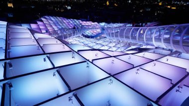 Sevilla 'daki Metropol Şemsiyesi' nin yükseltilmiş geçidi, geceleri turistlerin yürüdüğü mavi ve mor ışıklarla aydınlanıyor - SEVILLE, SPAIN - 25 Mart 2025