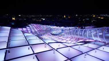 Metropol Şemsiyesi 'nin modern mimarisi, İspanya' nın Sevilla şehrinde geceleyin mor ve mavi ışıklarla parlayan SEVILLE, SPAIN - 25 Mart 2025