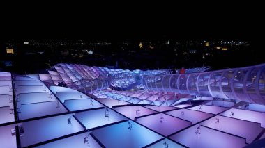 Metropol Şemsiyesi 'nin modern mimarisi, İspanya' nın Sevilla şehrinde geceleyin mor ve mavi ışıklarla parlayan SEVILLE, SPAIN - 25 Mart 2025