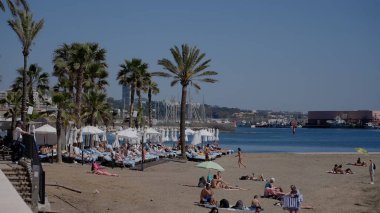 Marbella, İspanya 'da güneşli bir günde güneşlenen turistler - MARBELLA, İspanya - 30 Mart 2025