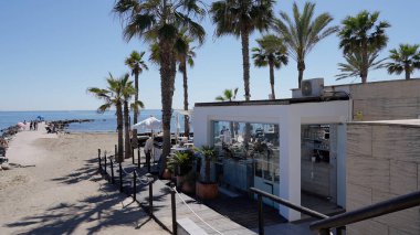 Palmiye ağaçları ve okyanus manzaralı İspanyol sahil restoranı Marbella, İspanya - 30 Mart 2025