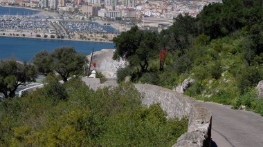 Cebelitarık Kayası 'ndan aşağı inen pitoresk yol aşağıda nefes kesici şehir ve marina manzarası sunuyor - GIBRALTAR, İngiltere - 31 Mart 2025