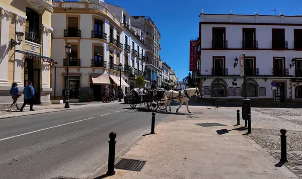 Beyaz at arabası turistlerle dolu Ronda, İspanya 'da, otelleri ve dükkanları olan - RONDA, SPAIN - 28 Mart 2025