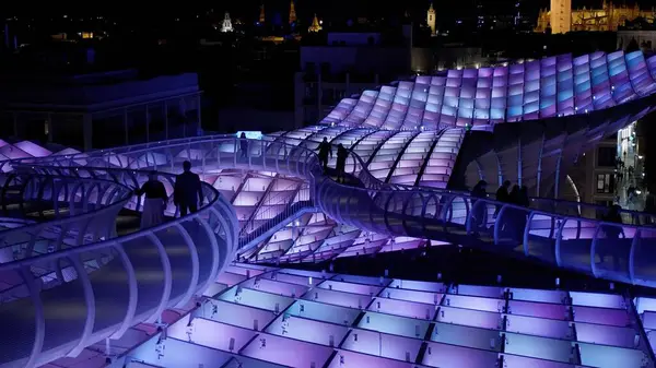 Metropol Şemsiyesi 'nin modern mimarisi, İspanya' nın Sevilla şehrinde geceleyin mor ve mavi ışıklarla parlayan SEVILLE, SPAIN - 25 Mart 2025