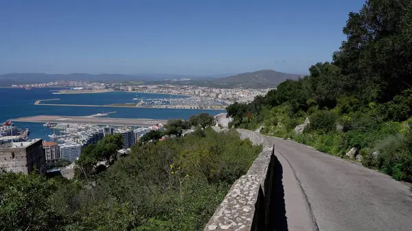 Cebelitarık Kayası 'ndan inen ve şehrin, limanın, havaalanının ve Cebelitarık Körfezi' nin panoramik manzarasını sunan dolambaçlı bir yolun manzarası - GIBRALTAR, İngiltere - 31 Mart 2025