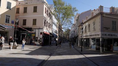 Güneşli bir günde, Gibraltar 'ın ana alışveriş caddesi olan İrlanda Kasabası' nda yürüyen insanlar - GIBRALTAR, İngiltere - 31 Mart 2025
