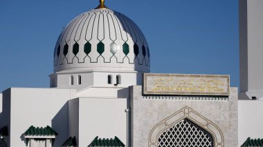 Koyu mavi gökyüzü altında parlayan yeşil kubbeli beyaz İslami cami - GIBRALTAR, İngiltere - 31 Mart 2025