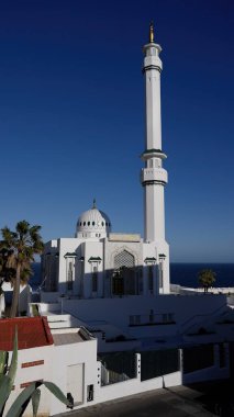 Kral Fahad Bin Abdul Aziz Al Saud Camii 'nin açık mavi gökyüzü altında parlayan minare ve Arapça yazıtlarla düşük açılı görüntüsü - GIBRALTAR, İngiltere - 31 Mart 2025