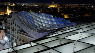 Metropol Şemsiyesi 'nin modern mimarisi, İspanya' nın Sevilla şehrinde geceleyin mor ve mavi ışıklarla parlayan SEVILLE, SPAIN - 25 Mart 2025