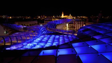 Metropol Şemsiyesi 'nin modern mimarisi, İspanya' nın Sevilla şehrinde geceleyin mor ve mavi ışıklarla parlayan SEVILLE, SPAIN - 25 Mart 2025