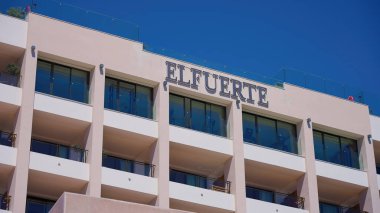 Modern otel cephesi açık mavi gökyüzünün altındaki yaz güneşini yansıtıyor - MARBELLA, İspanya - 30 Mart 2025