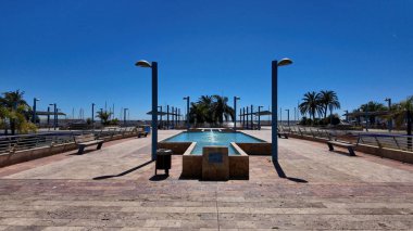 Güneşli İspanya 'da Marbella marinasını süsleyen palmiye ağaçları olan modern çeşme - MARBELLA, İspanya - 30 Mart 2025