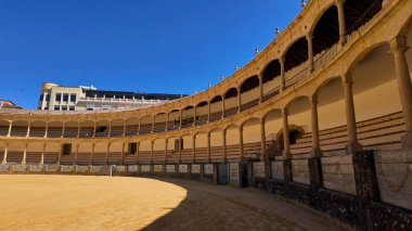 Ronda 'daki tarihi boğa güreşinin güneşli kemerleri açık mavi gökyüzünün altında - RONDA, SPAIN - 28 Mart 2025