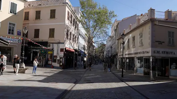 Güneşli bir günde, Gibraltar 'ın ana alışveriş caddesi olan İrlanda Kasabası' nda yürüyen insanlar - GIBRALTAR, İngiltere - 31 Mart 2025