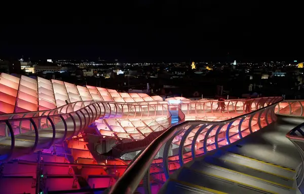 İspanya 'nın Sevilla kentindeki Metropol Şemsiyesi' nin gelecekteki ahşap yapısı gece canlı renklerle parlayarak çarpıcı bir şehir manzarası yaratıyor - SEVILLE, SPAIN - 25 Mart 2025