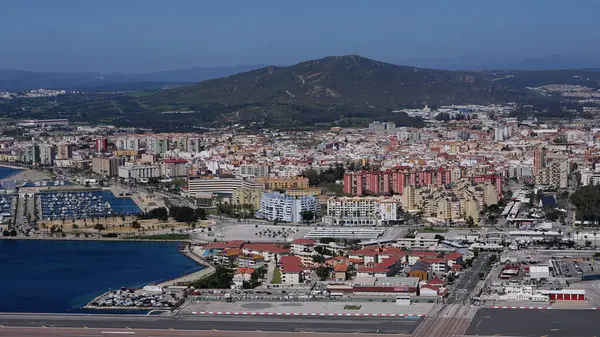 Gibraltar Uluslararası Havaalanı Pisti 'nin arka planda şehir, binalar, marina ve Cebelitarık Kayası ile kesişen havadan görüntüsü - GIBRALTAR, İngiltere - 31 Mart 2025