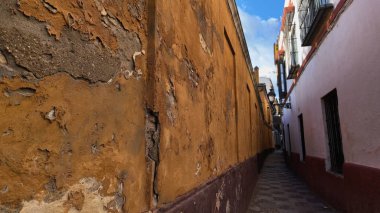 İspanya, Seville 'de dar bir sokak. Kırık alçıyla kaplı büyük bir duvar var. Şehrin tarihi mimarisini gözler önüne seriyor.