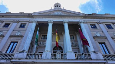 Mavi gökyüzü altında Endülüs ve İspanyol bayrakları sallayan Cadiz İl Konseyi 'nin düşük açılı görüntüsü