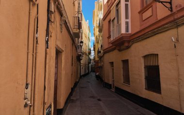 Geleneksel mimari ve canlı renkler, İspanya 'nın Cadiz kentinde kentsel hayata şöyle bir göz atma imkanı sunan pitoresk dar bir caddeyi tanımlıyor.