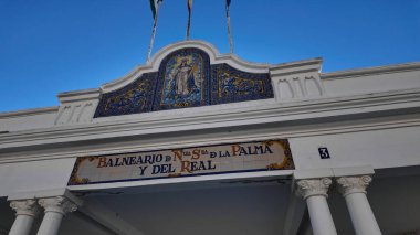 İspanya 'nın Cadiz kentinde rüzgarda dalgalanan renkli mozaik ve bayraklı Balnear de la Palma binası