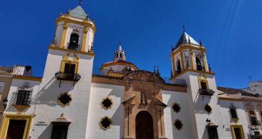 İspanya, Marbella 'da mavi gökyüzünün altında sarı detaylar ve çan kuleleriyle Encarnacion Kilisesi' nin beyaz cephesi