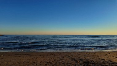 Altın gün batımı sakin Marbella plaj dalgalarını yansıtıyor