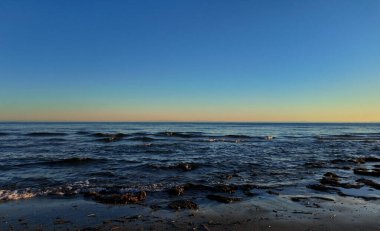 İspanya, Marbella 'nın kumlu sahillerini güzel bir günbatımında yıkayan küçük dalgalar.