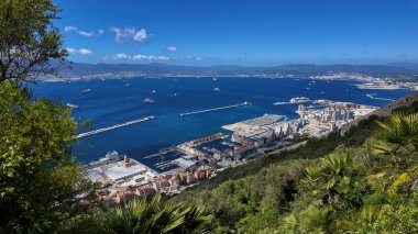 Cebelitarık şehri, körfez ve Algeciras Körfezi 'nin panoramik görüntüsü güneşli bir günde limana girip çıkan kargo gemileri, yolcu gemileri ve diğer gemileri gösteriyor.
