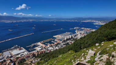 Cebelitarık şehri, limanı ve Boğaz 'ın panoramik manzarası. Güneşli bir günde yelken açan kargo gemileri ve yolcu gemileri.