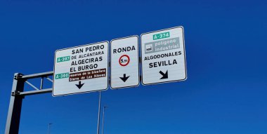 İspanya, Endülüs 'teki yol işaretleri, açık mavi gökyüzü altındaki farklı şehir ve kasabaların yönlerini gösteriyor.
