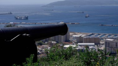 Eski top Cebelitarık Körfezi 'ni işaret ediyor. Şehir ve gemiler arka planda.