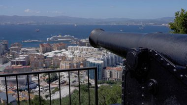 Şehre ve Cebelitarık limanına bakan eski top. Arka planda yolcu gemisi var.
