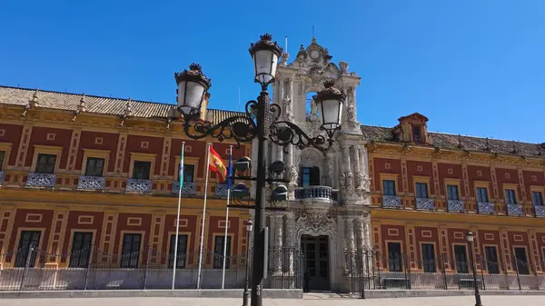 Güneşli bir yaz gününde Sevilla, İspanya 'daki San Telmo Sarayı' nın önünde duran süslemeli sokak lambası.