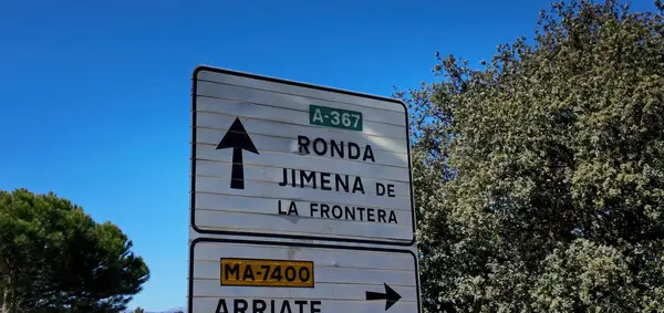 İspanya, Endülüs 'te açık mavi gökyüzünün altında Ronda ve Jimena de la Frontera' ya giden yolu gösteren tabelalar.