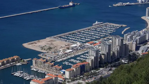 Ocean Village Marina 'nın hava manzarası, lüks yatlar, konut binaları ve Cebelitarık' ın hareketli limanı.
