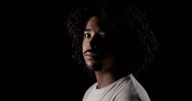 Siyah bir geçmişi olan kıvırcık saçlı Afro-Amerikan bir adamın portresi.