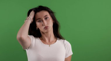 Krom anahtar arka planda el saçı pozu veren genç bir kadın. Reklam ve pazarlama kampanyaları için ideal.