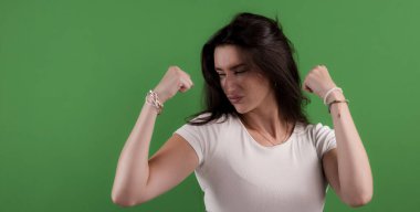 Moda modeli bisepslerini yeşil ekran arka planında gösteriyor