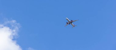 Londra, İngiltere - 5 AĞUSTOS 2025 - Mavi gökyüzü ve beyaz bulutlarla dolu güzel bir günde Londra üzerinde uçan yolcu uçağı