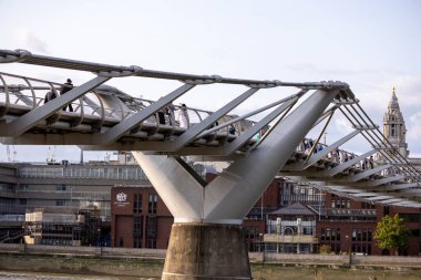 LONDON, İngiltere - 5 AĞUSTOS 2025 - Londra 'daki Milenyum Köprüsü üzerinde güneşli bir günün tadını çıkaran turistler, Londra Okulu manzaralı