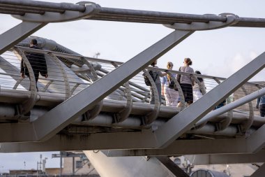 LONDON, İngiltere - 5 AĞUSTOS 2025 - Londra, İngiltere 'de güneşli bir günde Milenyum Köprüsü' nü geçen insanlar