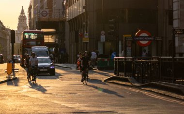 LONDON, UK - 5 AĞUSTOS 2025 - St. Paul Katedrali yakınlarındaki Londra 'da gün batımında bisiklet, araba ve kırmızı otobüslü şehir trafiği