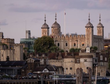 LONDON, İngiltere - 5 AĞUSTOS 2025 - Londra Kulesi 'nin günbatımında İngiliz bayrağı dalgalanması, tarihi bir dönüm noktası ve Londra, İngiltere' de popüler bir turizm merkezi