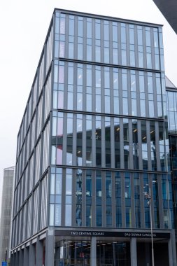 CARDIFF, İngiltere - 8 AĞUSTOS 2025 - Cardiff Üniversitesi Gazetecilik, Medya ve Kültür Araştırmaları Okulu 'na ev sahipliği yapan İki Merkez Meydanı' nın modern cam cephesi, kentsel çevreyi yansıtıyor