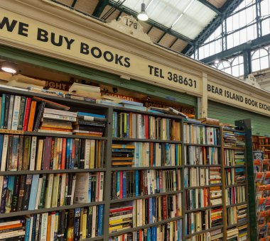 CARDIFF, İngiltere - 8 AĞUSTOS 2025 - Kullanılmış kitaplarla dolu kitaplıklar Galler, Cardiff Market 'teki Bear Island Kitap Borsası' nda sergilenmektedir