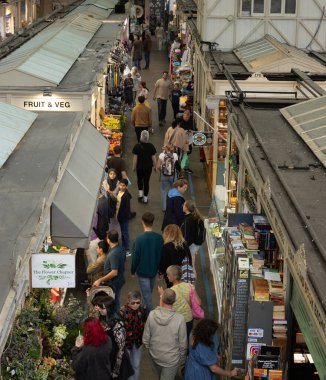 CARDIFF, İngiltere - 8 AĞUSTOS 2025 - Galler 'de tarihi bir eser olan Cardiff kapalı pazarında yeni ürünler ve yerel el sanatları keşfeden ve satın alan insanlar