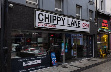 CARDIFF, İngiltere - 8 AĞUSTOS 2025 - Cardiff şehir merkezindeki Chippy Lane restoranında kebap, balık ve cips gibi fast food satan bir şef