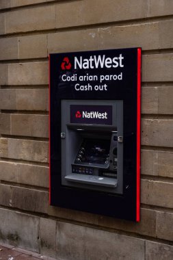 CARDIFF, İngiltere - 8 AĞUSTOS 2025 - Modern ATM Cardiff, Galler 'deki taş bir duvarda finansal hizmetler sunuyor