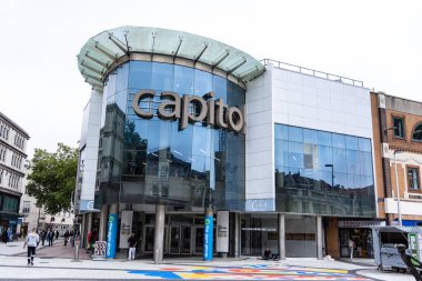 CARDIFF, İngiltere - 8 AĞUSTOS 2025 - Capitol Alışveriş Merkezi 'nin modern cam cephesi, Cardiff şehir merkezi, Galler, Birleşik Krallık' taki bulutlu bir günde çevresindeki binaları yansıtıyor